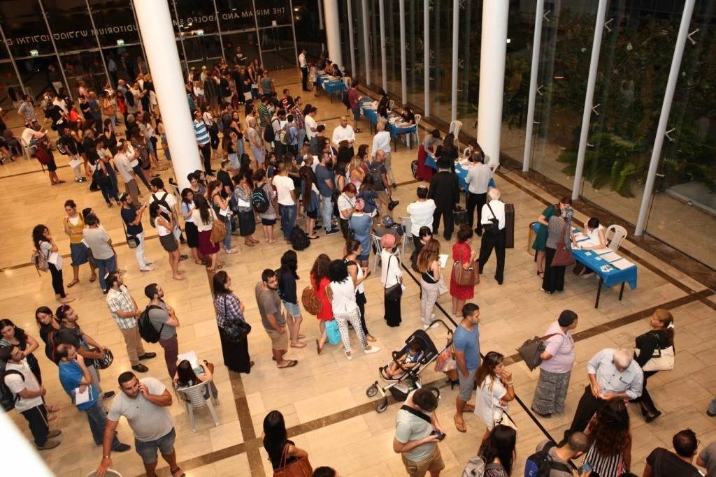 אנשים בתור לעמדות רישום בטקס הענקת מלגות של קרן מכבים